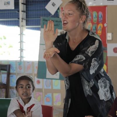 A Projects Abroad volunteer teaches children during her cultural immersion in Samoa. A volunteer in a village in Samoa teaches children at a school.